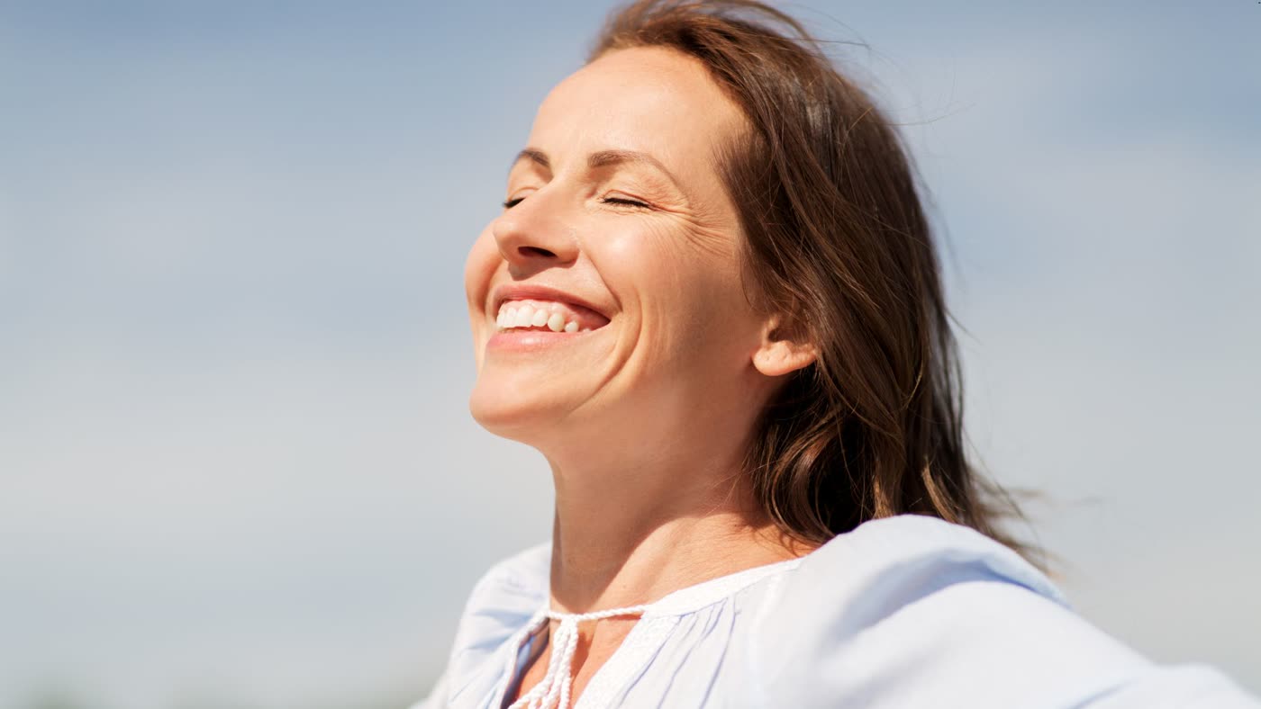 Mujer feliz y en paz al sol